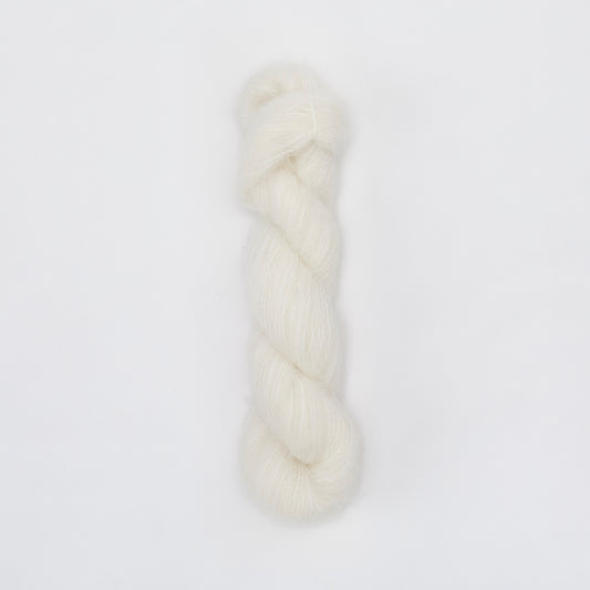 Kinua The Fuzzy yarn in soft, plush texture with creamy white color, ideal for cozy knitting projects.