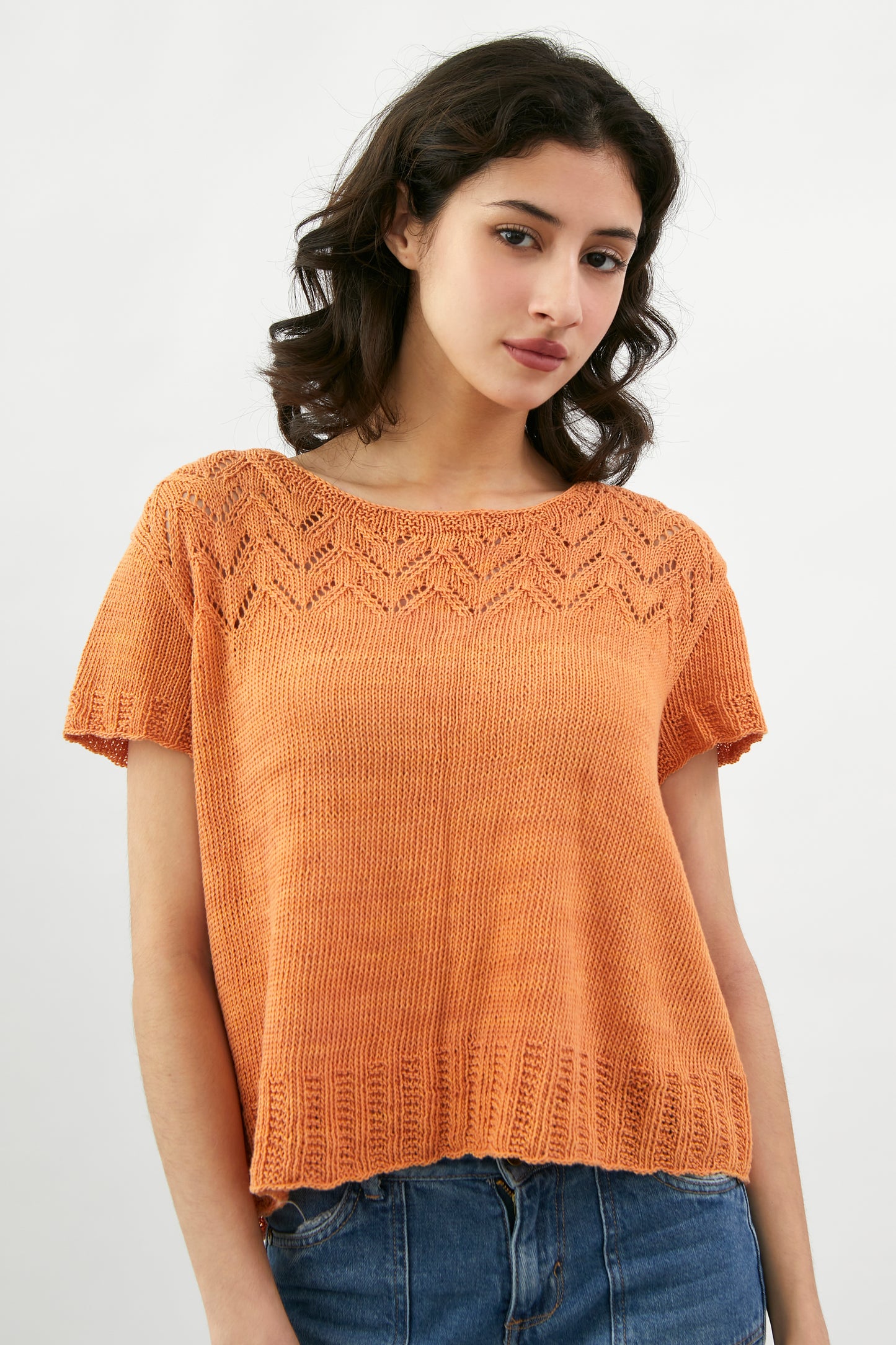 Kinua Amelie Tee featuring a vibrant pattern with short sleeves and a relaxed fit, displayed on a neutral background.