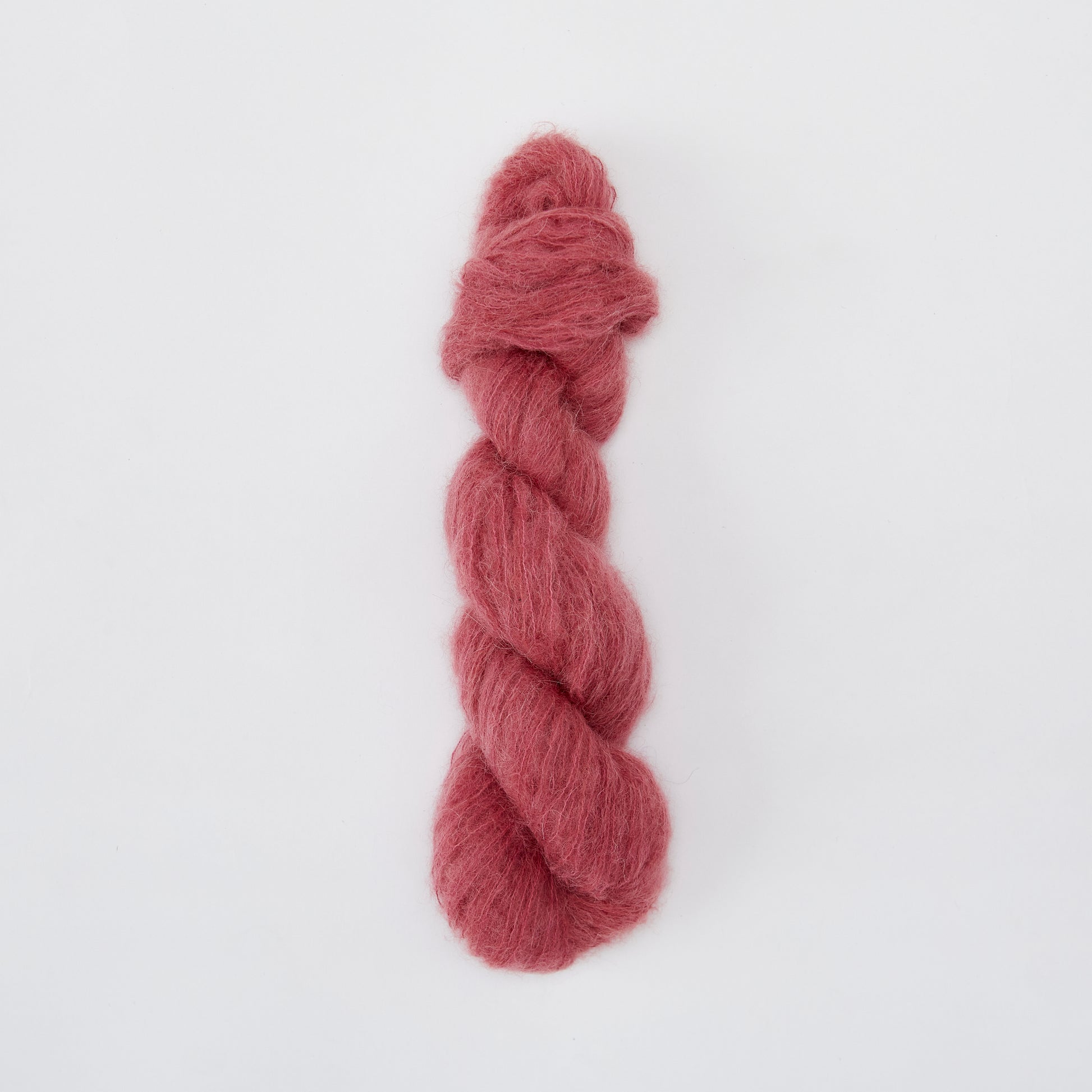 Close-up of Kinua The Fuzzy yarn showing its soft, fuzzy texture in a vibrant color, ideal for cozy knitting projects.