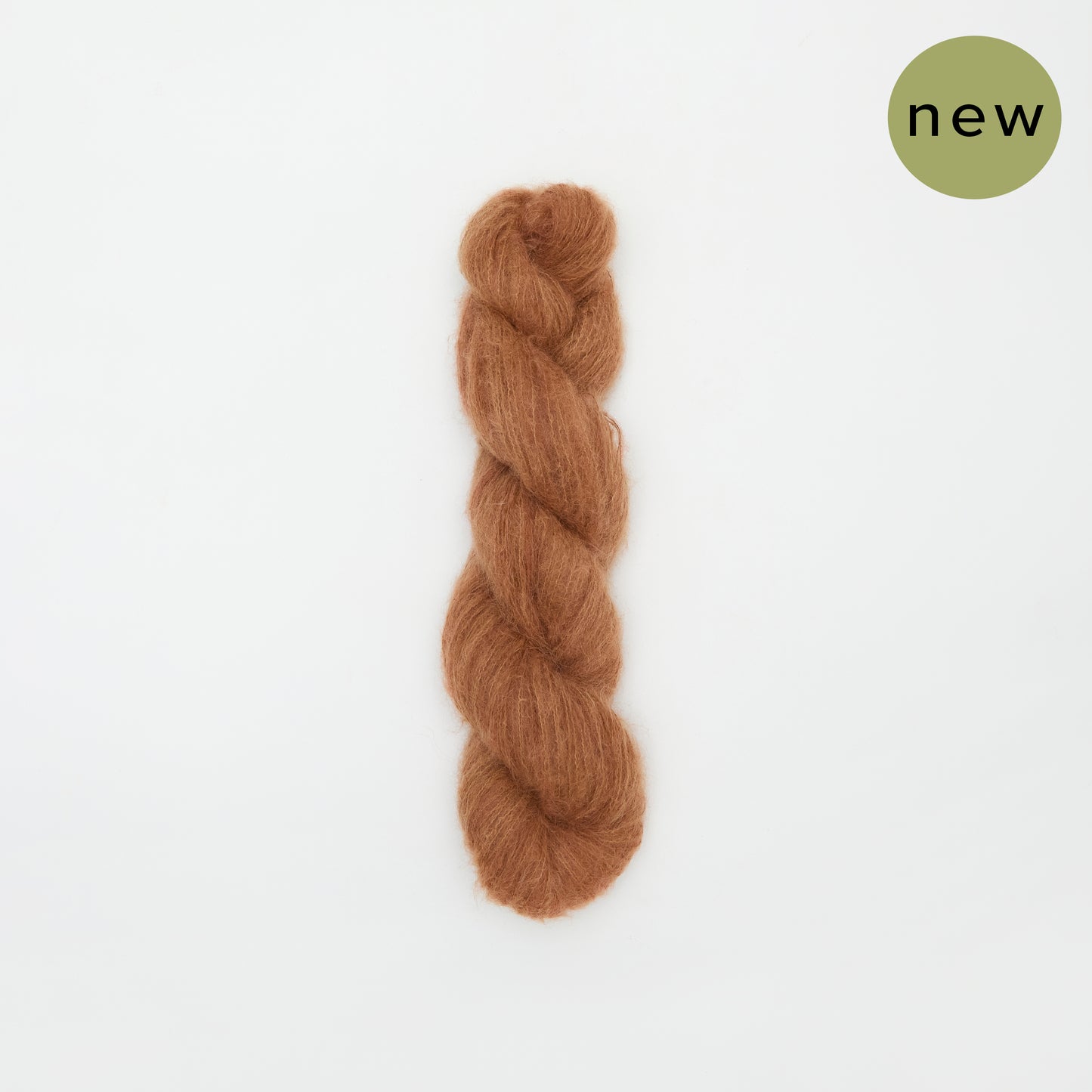Rusty colored Kinua The Fuzzy yarn ball showcasing soft, fuzzy texture ideal for knitting and crochet projects.