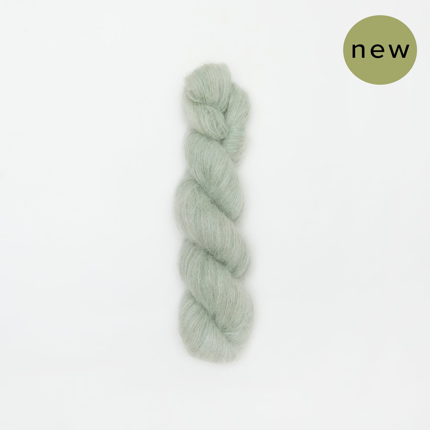 Kinua The Fuzzy yarn in Aquamarine, soft fuzzy knitting yarn with vibrant aqua color, close-up view of textured fiber strands.