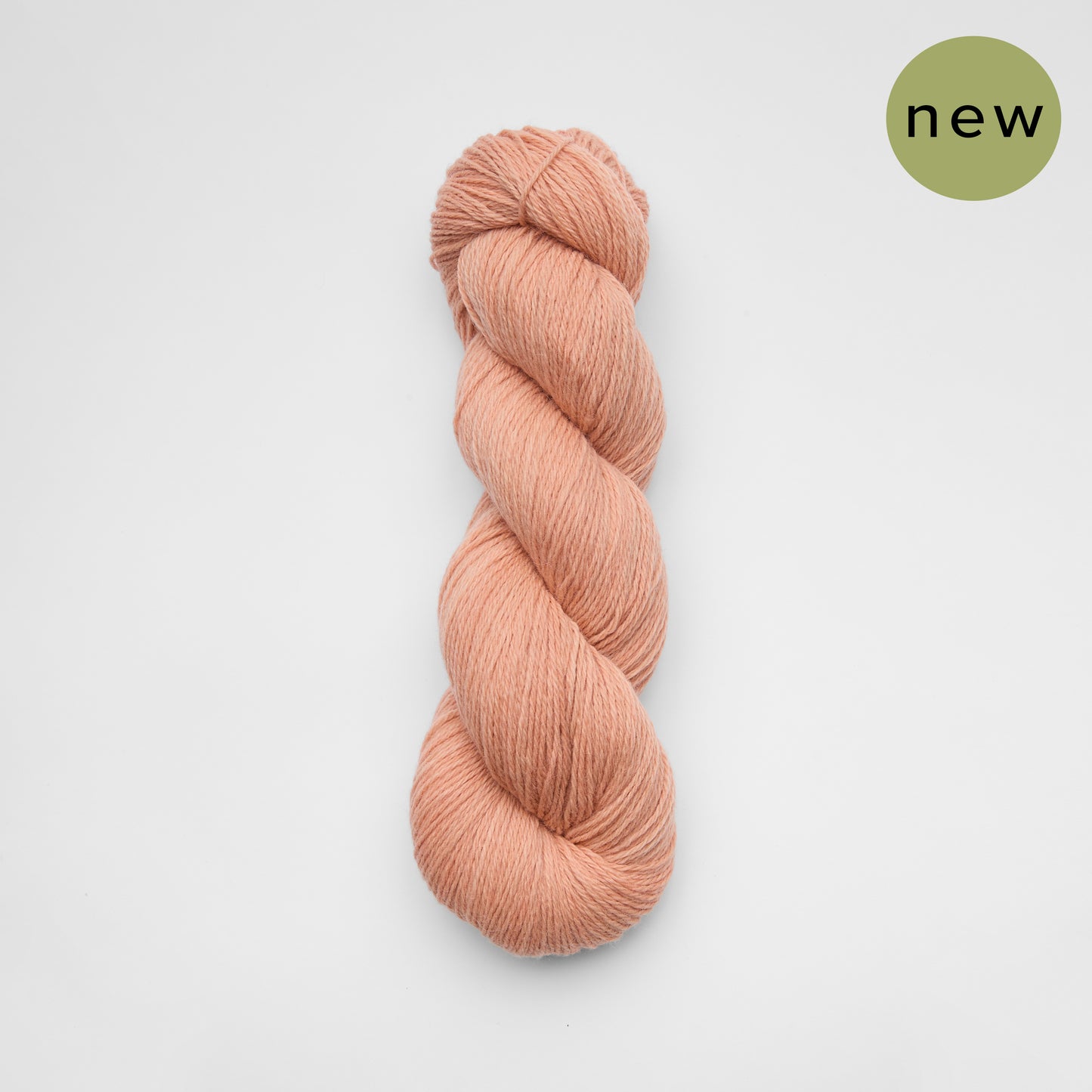 Kinua The Fingering Luxury Blend yarn in blush pink, showing soft, smooth texture and vibrant color for knitting and crochet projects.