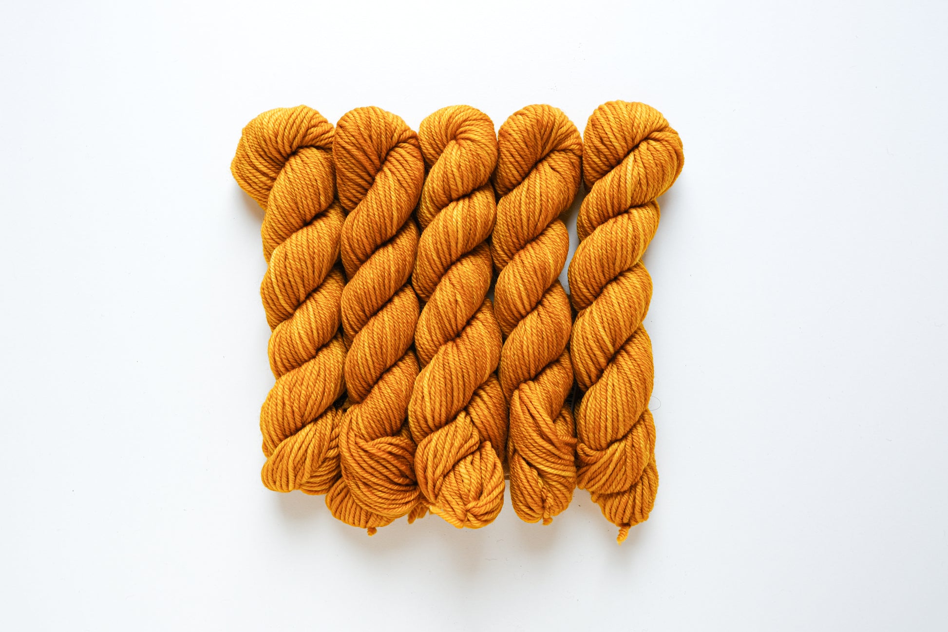 Fairmount Fibers Alegria Grande Bocados yarn in Turmeric color, showcasing vibrant, soft, and textured fiber strands.