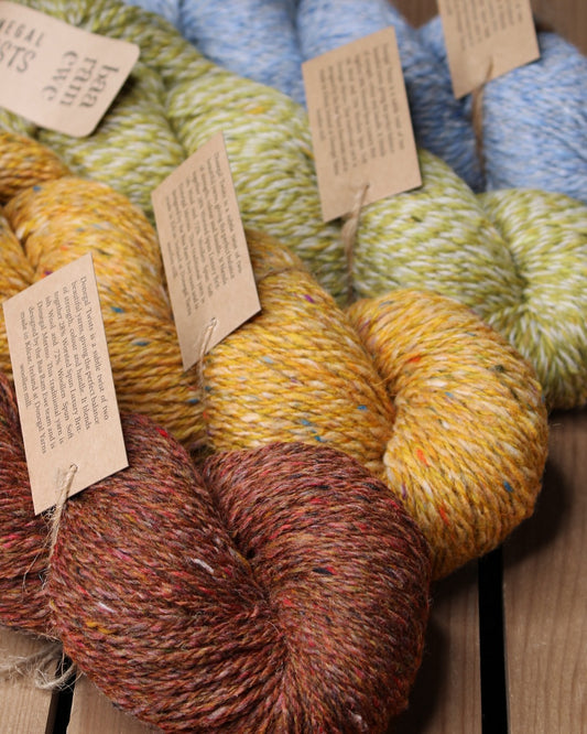 Baa Ram Ewe Donegal Twists yarn in natural wool with colorful flecks, ideal for knitting and crochet projects.