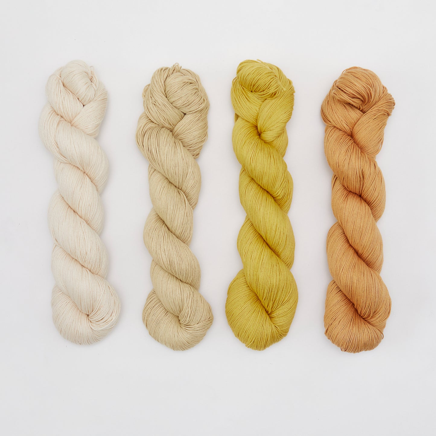 Organic cotton yarn from Kinua, The Fingering, showcasing soft, natural fibers in a close-up view.