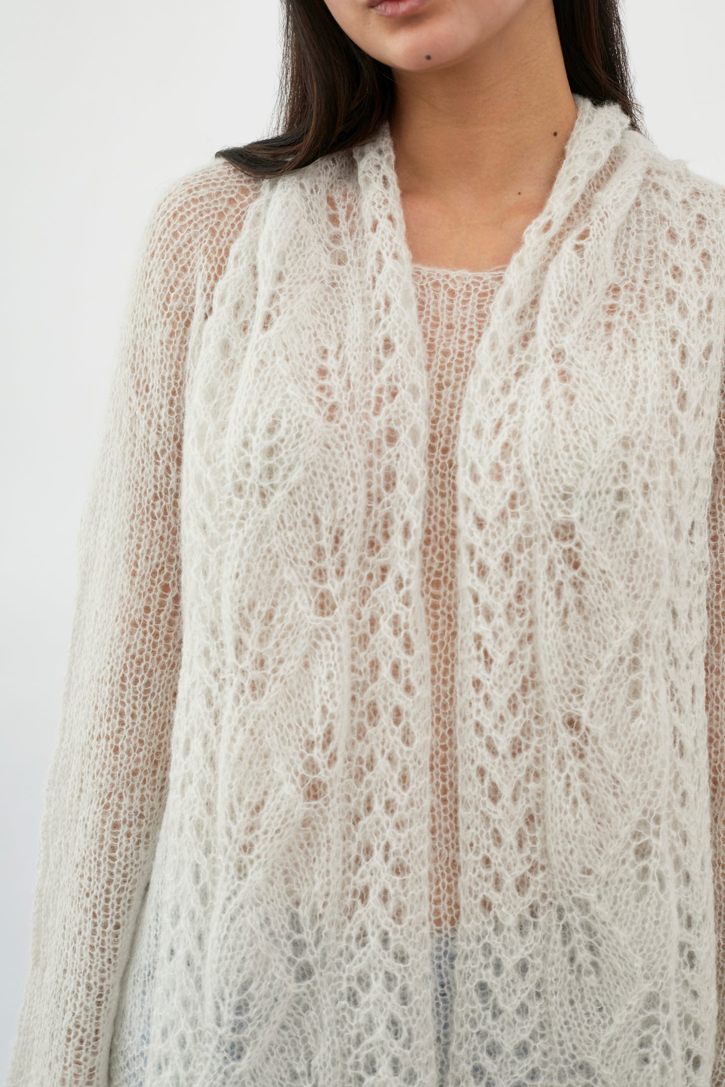 Close-up of a fuzzy patterned scarf by Kinua, showcasing soft texture and intricate design in cozy, warm tones.