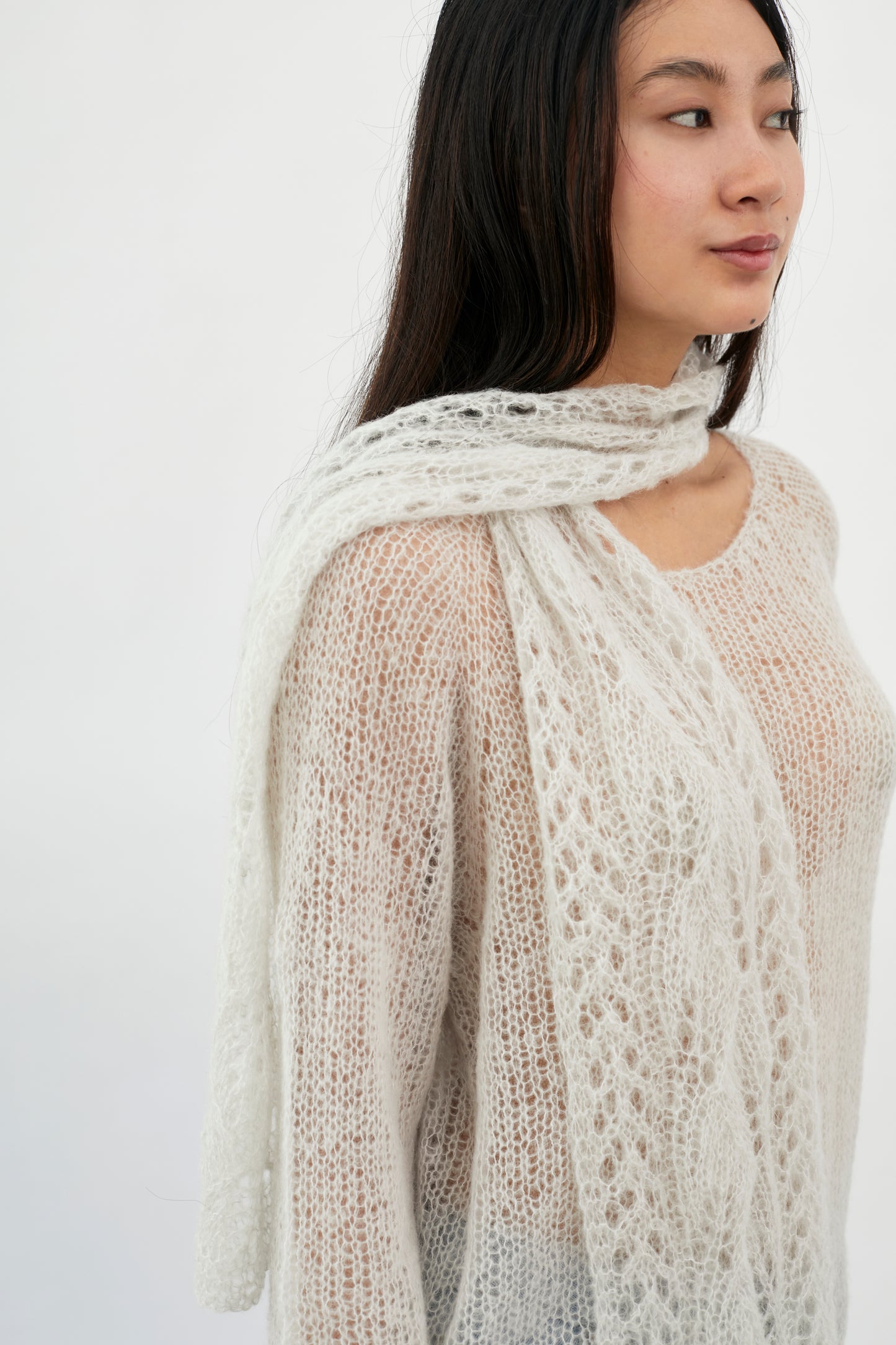Close-up of Kinua The Fuzzy Scarf with a cozy, patterned knit design in soft, warm tones.
