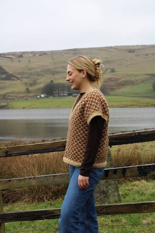 Close-up of Baa Ram Ewe Odette pattern yarn sample showcasing soft, intricate knitting design in natural wool tones.
